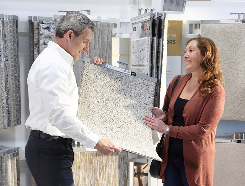 Staffer showing customer some carpet samples 